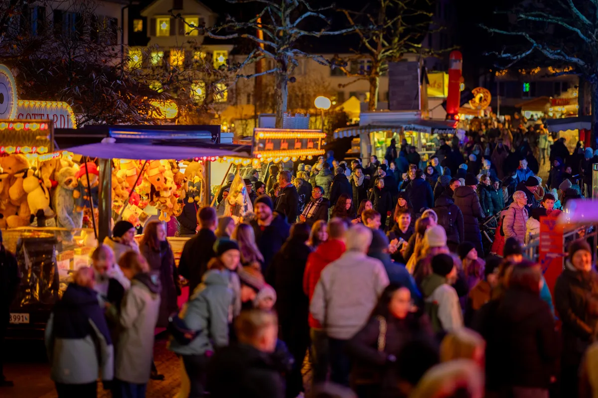 Man sieht grosse Menschenmengen vor Marktständen. 